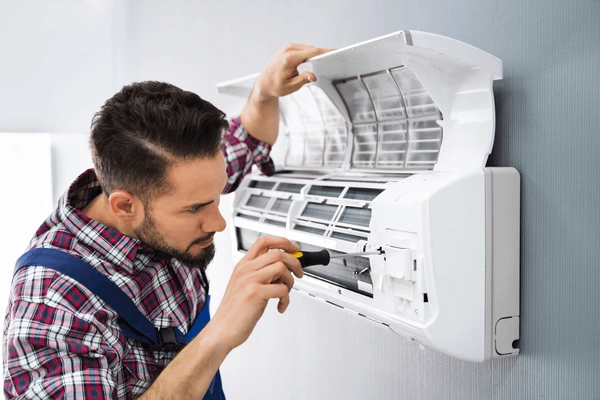 Om Sai Service technician repairing a split air conditioner
